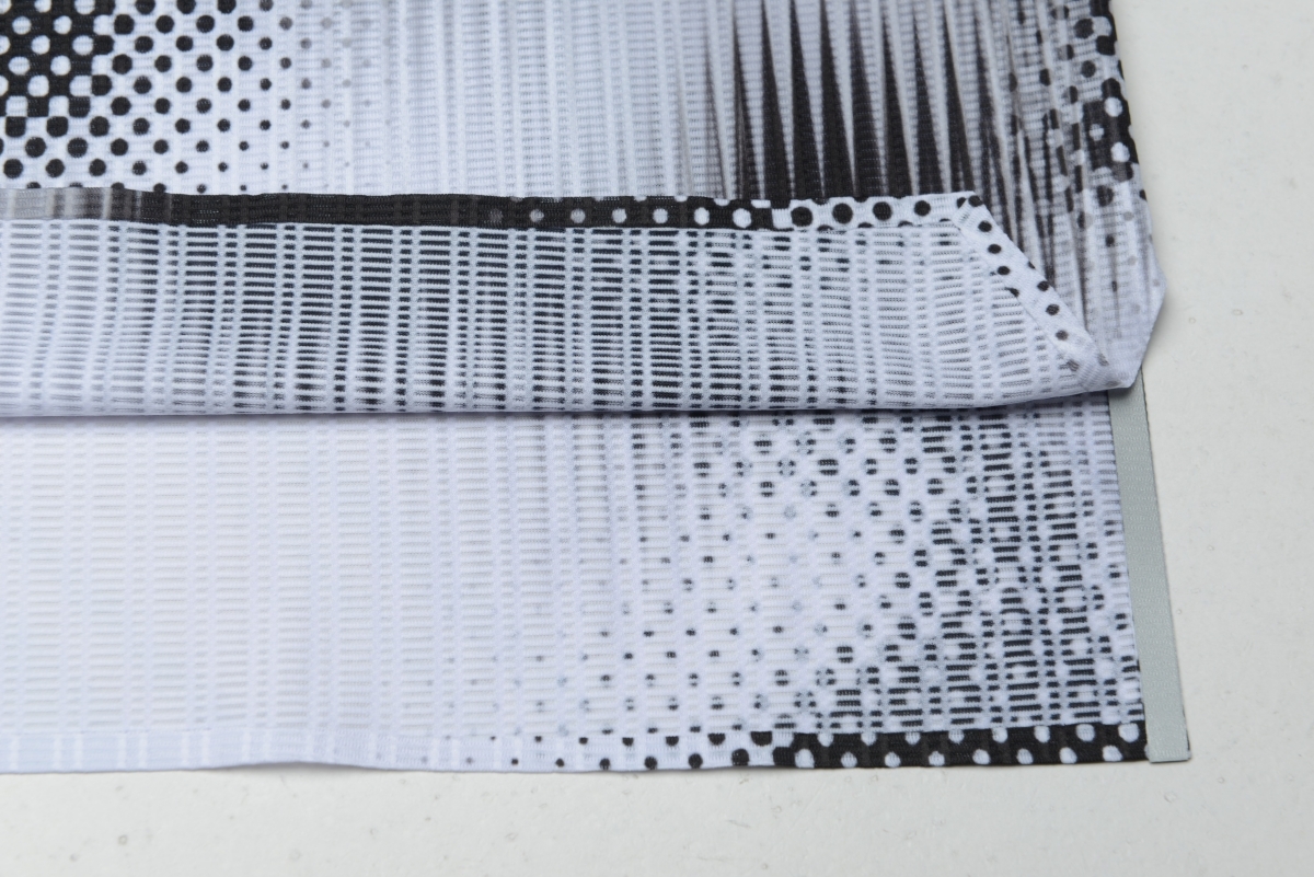 hem detail showing sublimated print, breathable grid texture, and layered side opening